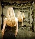a woman standing in front of mirror tying to find the perfect woman within