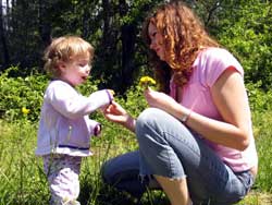 mother sitting with her child and teaching love by offering flowers