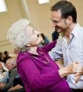 a young man take care of elderly lady and dancing with her