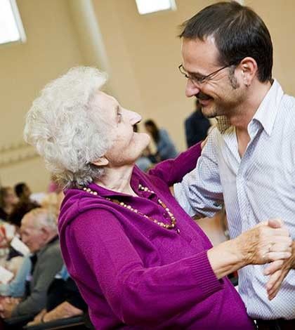 a young man take care of elderly lady and dancing with her