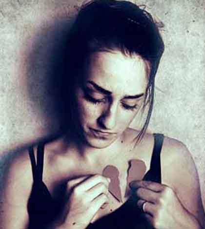 a girl holding broken apart pieces of heart in her hand