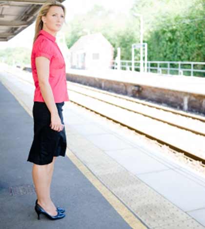 Upset mother keeping calm and standing at platform waiting for the train