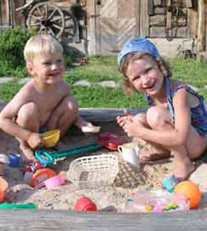 two children behave like real children playing and having fun in the sandpit