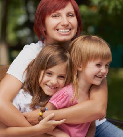 mother holding two joyful kids in arms