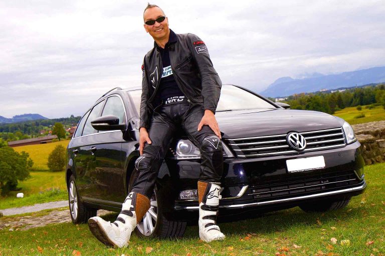 Happy man in front of the insured car he owns