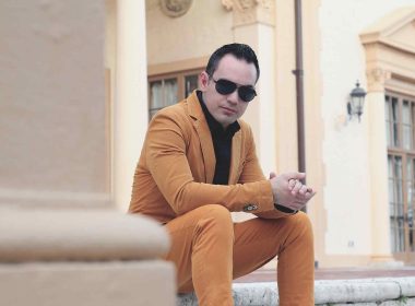 Man dressed in mustard fashion suit sitting on the stairs.