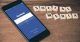 A mobile with Facebook login page and social media alphabet blocks