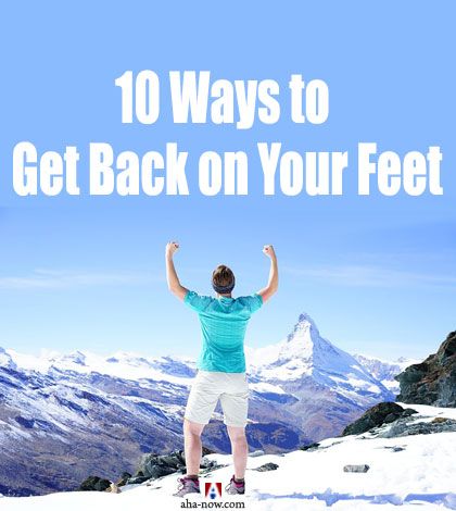 Man happy with raised arms to get back on feet on top of a snow clad mountain