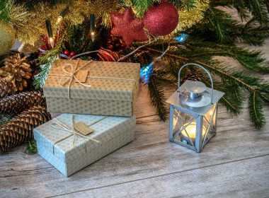 Gifts, lantern, and Christmas tree with decorations on the floor