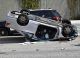 Car lying upside down on road after accident