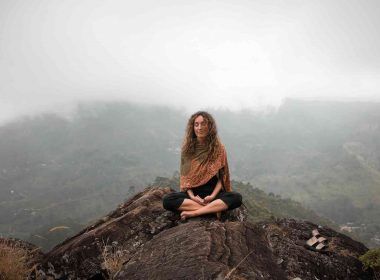 Woman on top of mountain in meditation as mindful practice