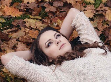 A married woman lying on leaves and thinking about her younger days