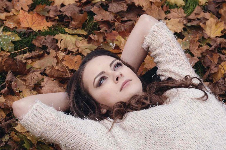 A married woman lying on leaves and thinking about her younger days