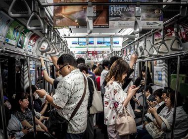 People in metro with mobile in hand indulging in instant gratification