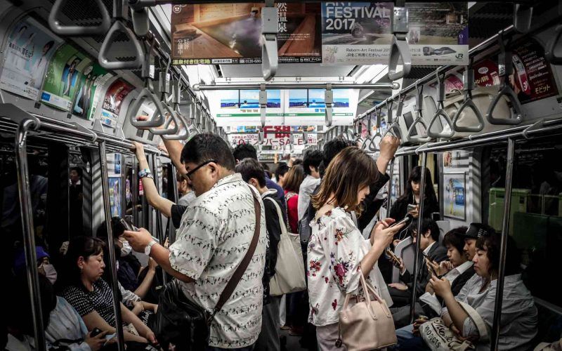 People in metro with mobile in hand indulging in instant gratification