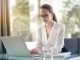 A woman in sitting in office working on laptop