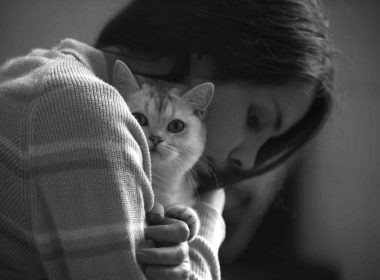 A girl hugging a cat to combat anxiety