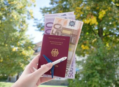 Passport and money in hand as important travel documents