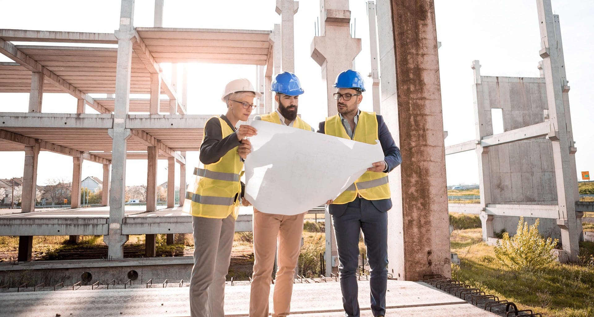 Three construction workers checking a map on a construction site