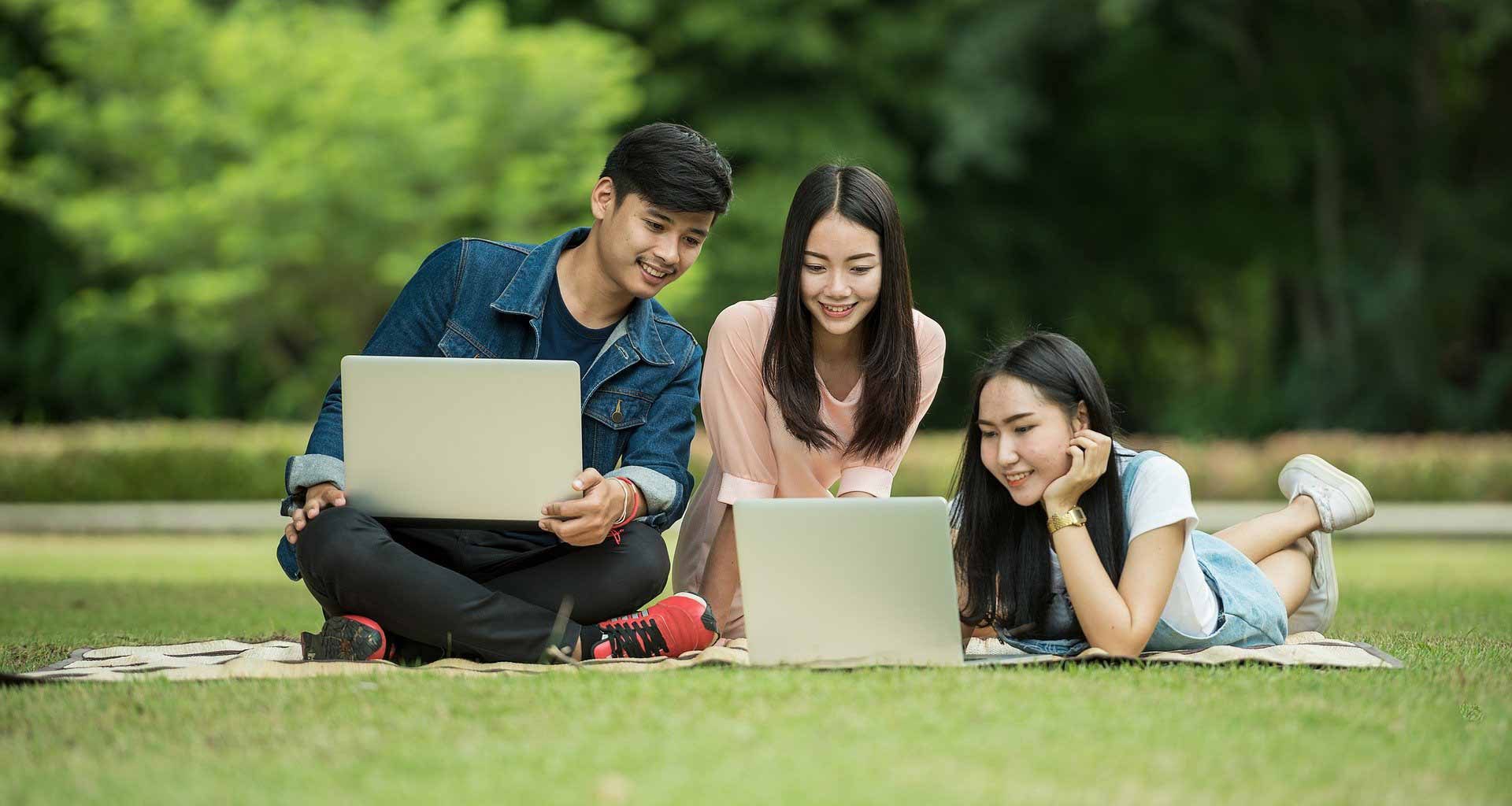 Three young professionals searching for health insurance on laptop