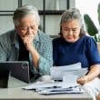 A couple analyzing Medicare papers to avoid default