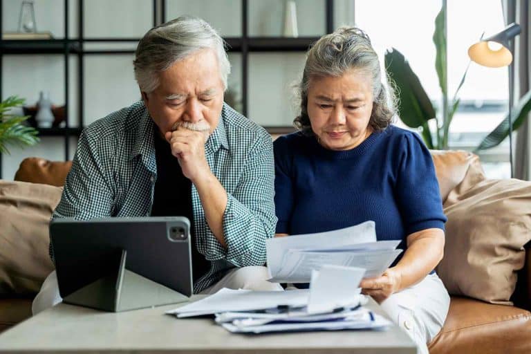 A couple analyzing Medicare papers to avoid default