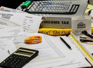 Income tax books, calculator, and taxpapers.